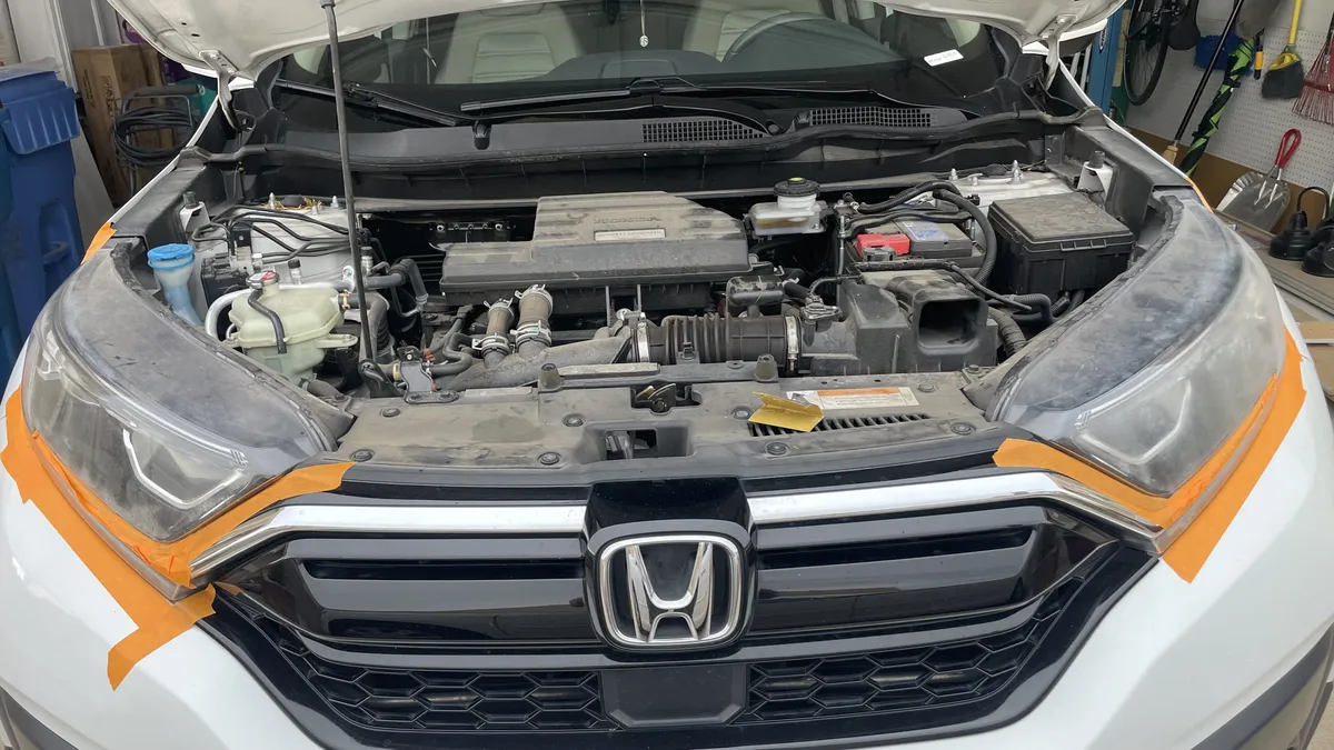 Honda CR-V engine bay detail during headlight restoration inspection.