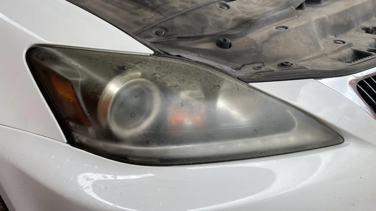 Before professional headlight restoration on 2012 Lexus IS 250 (Driver Side) in Tucson, AZ showing severe lens oxidation.