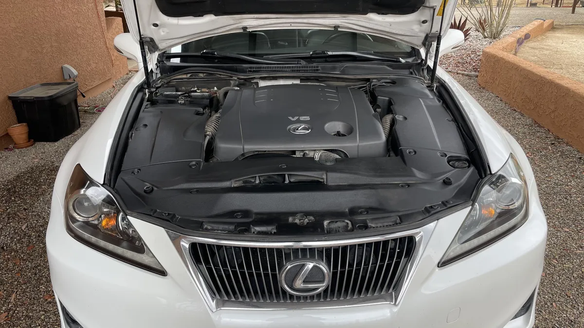 Lexus IS 250 engine bay detail during headlight restoration inspection.