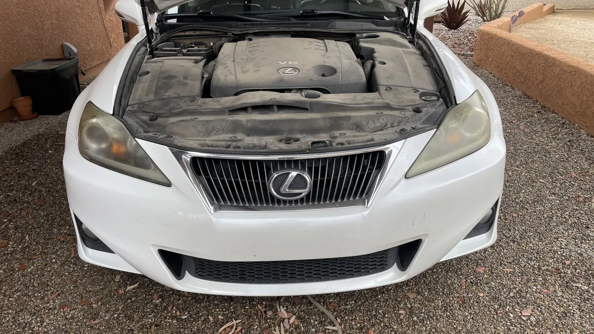 Lexus IS 250 engine bay detail during headlight restoration inspection.