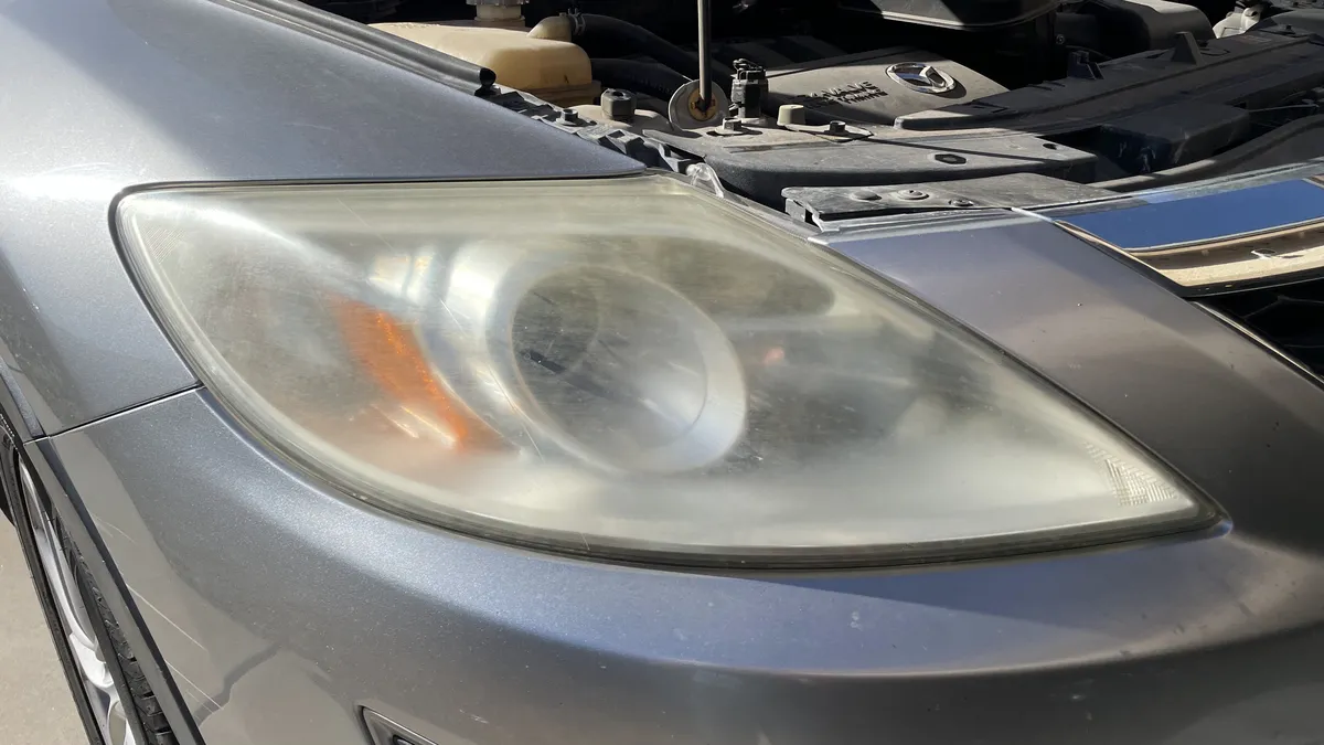 Before professional headlight restoration on 2011 Mazda CX-9 in Tucson, AZ showing severe lens oxidation.