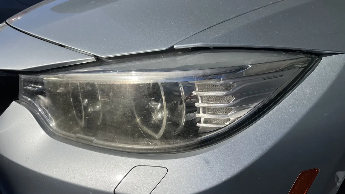 Yellowed headlight lens before comparing store-bought restoration kits with professional service