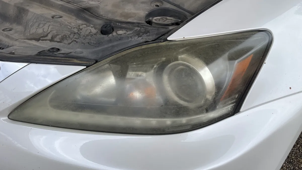 Cloudy headlight with sanding marks after a failed DIY restoration attempt.